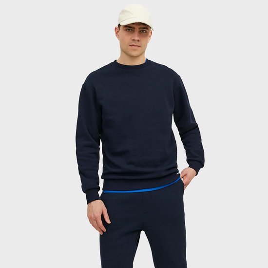 Man in een donkerblauwe sweater met een blauwe zoom aan de joggingbroek.
