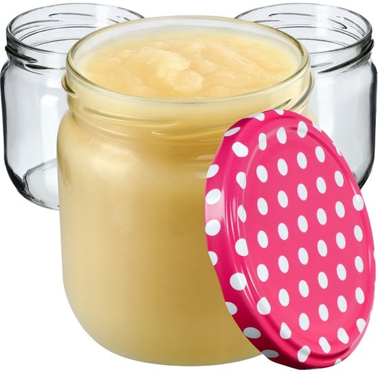 Bocal en verre rempli de compote de pommes, avec un couvercle rose à pois blancs, et deux bocaux vides.