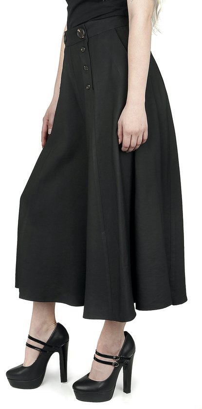 Zwarte wijde culotte met hoge taille, gedragen op zwarte platformpumps met bandjes.
