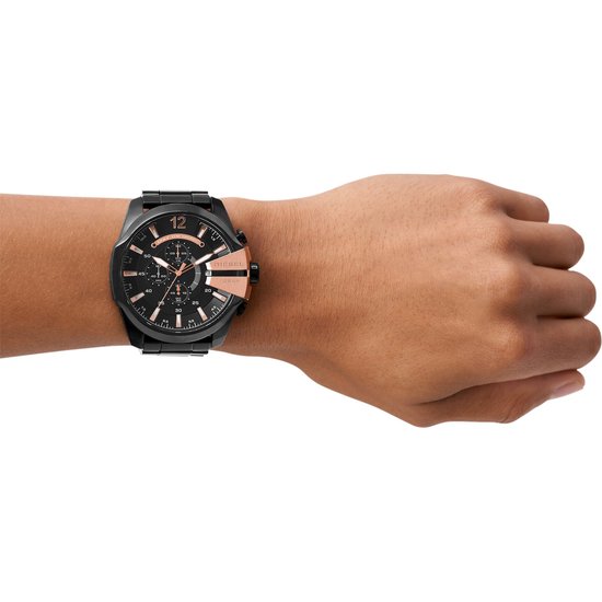 Zwart Diesel horloge met rosé gouden details, gedragen om een donkerdere huidskleur pols.