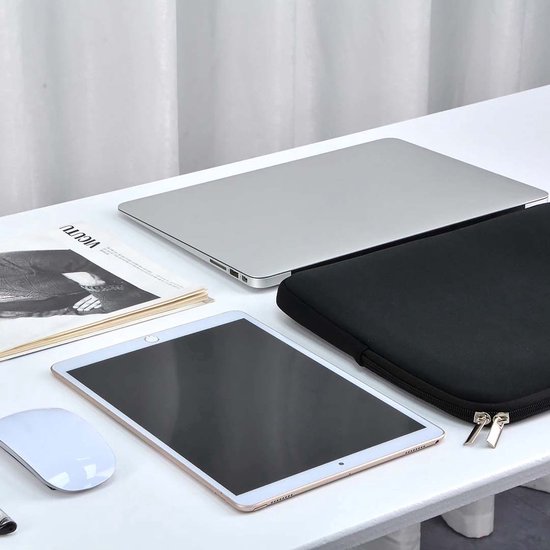 Housse d'ordinateur portable noire sur une table à côté d'un ordinateur portable, d'une tablette et d'une souris