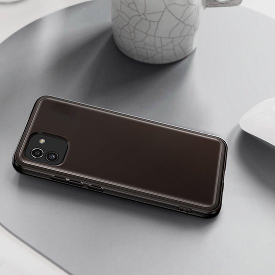 Zwart Samsung Galaxy A03 hoesje op een bureau naast een mok en muis.