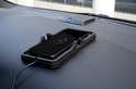 Zwarte Dunlop draadloze opladerhouder met smartphone die 57% is opgeladen, op een auto dashboard.