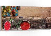 WallClassics - Hout - Geparkeerde Fiets bij Muur met Watermeloen Wielen - 100x50 cm - 9 mm dik - Foto op Hout (Met Ophangsysteem)