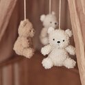 Close-up van drie teddyberen mobiel, met focus op de lichtbeige beer vooraan.