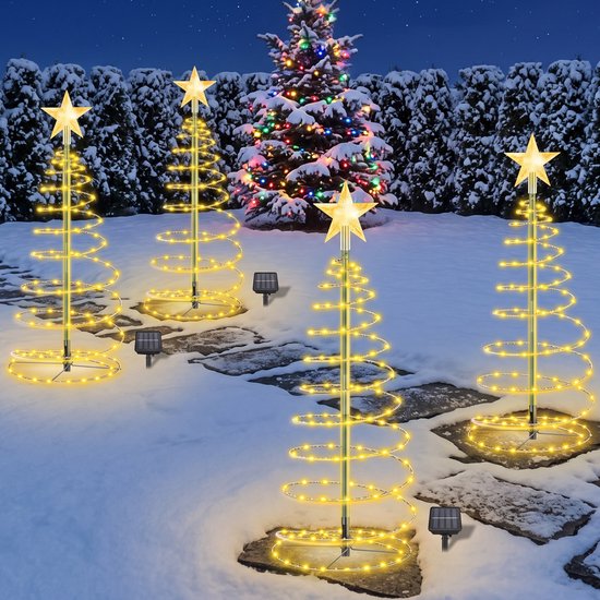 Quatre sapins de Noël en spirale à énergie solaire avec étoiles, installés dans un paysage enneigé.