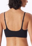 Achterkant van het model die een zwarte bustier met verstelbare bandjes draagt.