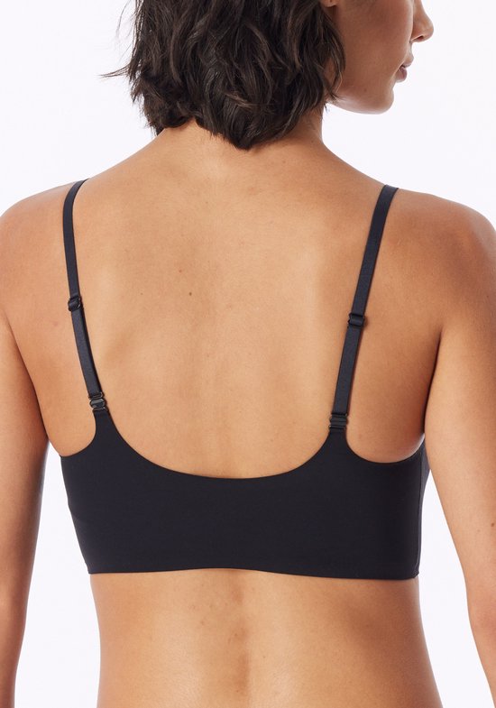 Achterkant van het model die een zwarte bustier met verstelbare bandjes draagt.