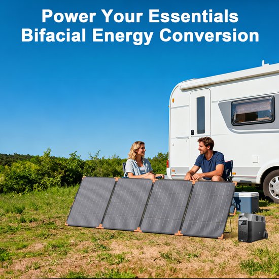 Koppel met zonnepanelen en camper op grasveld. Man en vrouw zitten in stoelen, kijken elkaar aan.