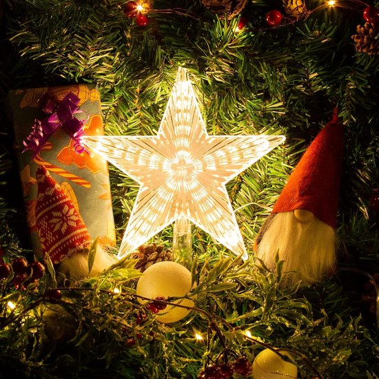 Verlichte kerstboomster met stralend patroon, geplaatst tussen kerstdecoraties zoals kabouters en dennenappels.