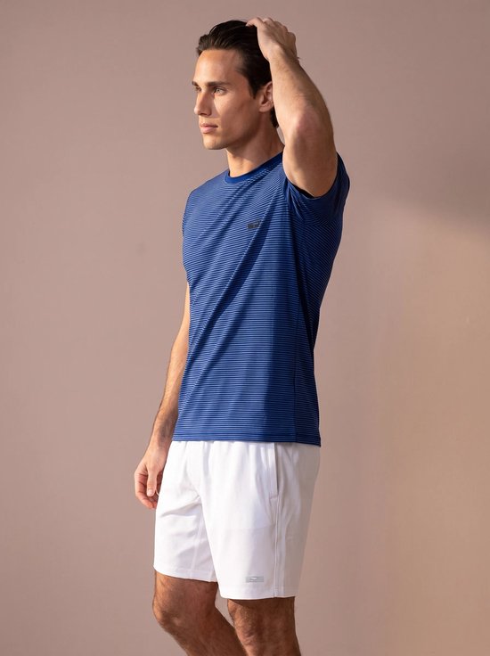 Zijaanzicht van een man in een blauw gestreept sportshirt en witte short, hand in het haar.