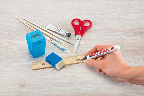 Tekengerei: Edding 400 stift in hand, puntenslijper, liniaal, gum, kwasten, schaar en tube verf.