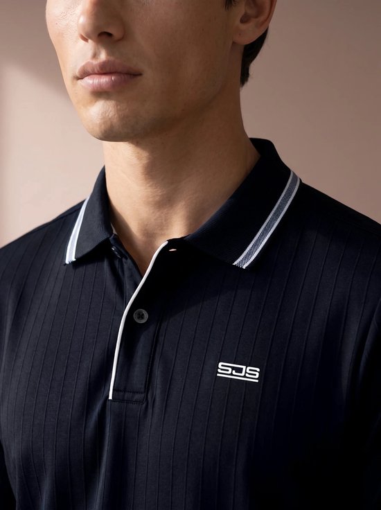 Detail van een donkerblauw poloshirt met verticale ribbels, een wit geborduurd logo SJS op de borst.
