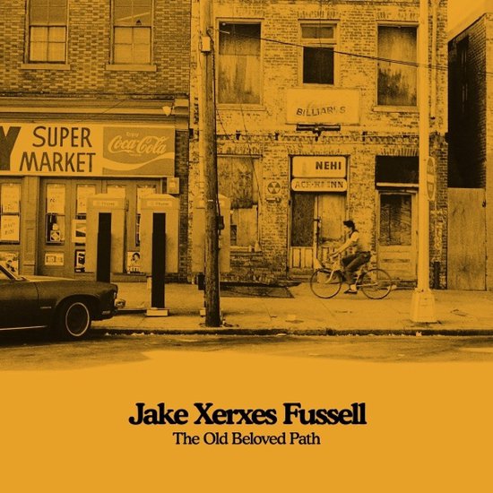 Pochette d'album sépia de The Old Beloved Path par Jake Xerxes Fussell, montrant une personne à vélo dans une rue.