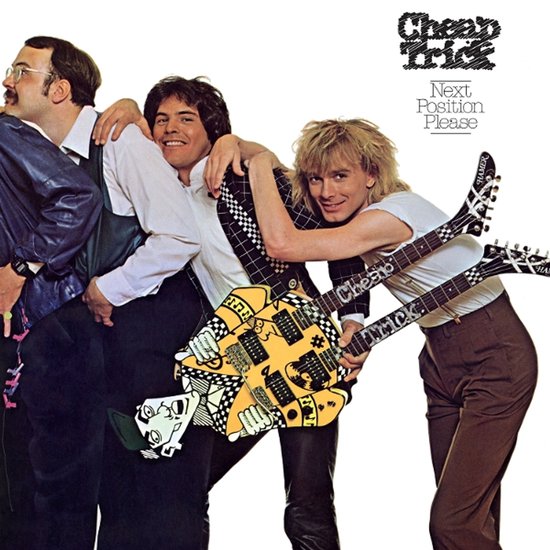 Drie bandleden van Cheap Trick poseren voor het album Next Position Please met een opvallende gele gitaar.