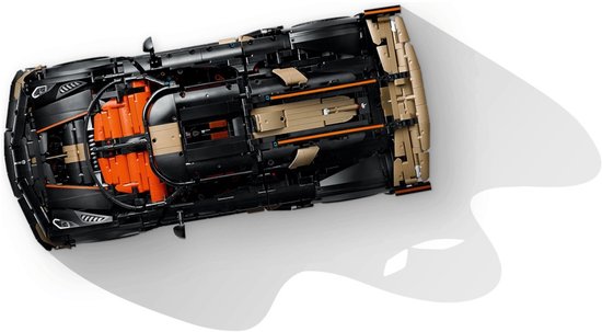 Onderkant van zwarte Koenigsegg speelgoedauto met oranje en gouden mechanische details.
