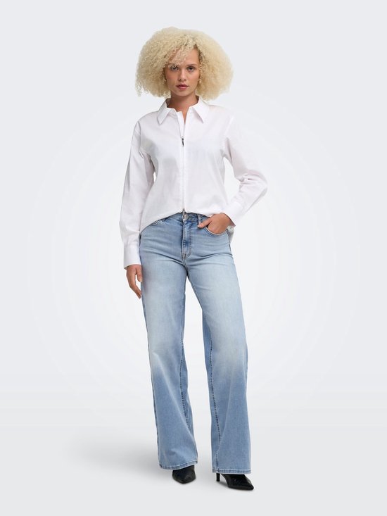 Model met blond krullend haar draagt een witte blouse en lichtblauwe ONLMADISON jeans met wijde pijpen.