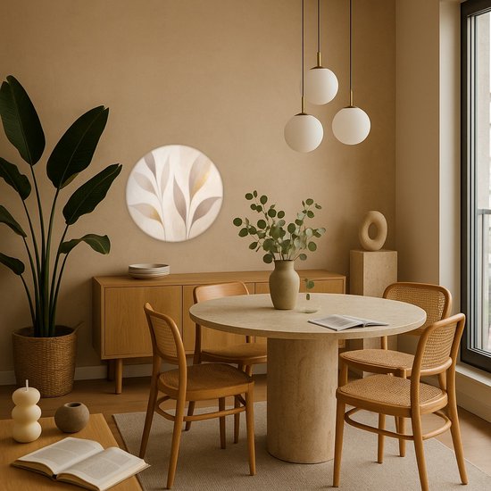 Ronde wandcirkel met abstracte bladeren in beige en goudtinten, boven een houten dressoir in een eetkamer.