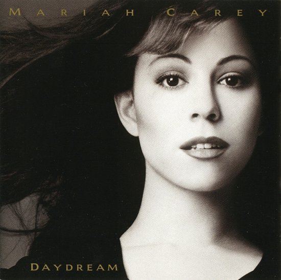 Zwart-wit portret van Mariah Carey op het album Daydream, met haar naam en titel bovenaan en onderaan in goud.