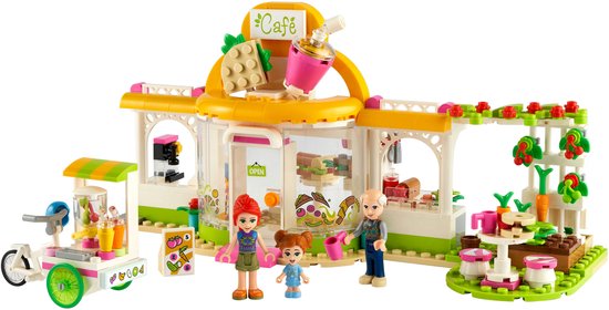 LEGO Friends café set met drie miniatuurfiguren, een foodtruck en groen versierde uitbreidingen. Het café is wit met een oranje dak.
