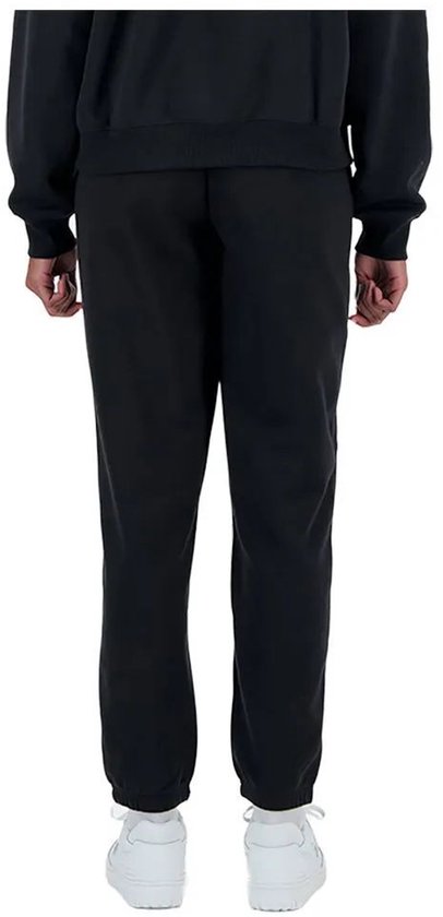 Achterkant van een zwarte joggingbroek met witte New Balance logo op linkerbeen.