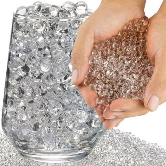 Handen vol transparante waterparels, naast een glas gevuld met de parels.