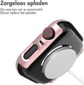 Rosegouden smartwatch case, verbonden met een oplader.
