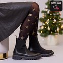 Zwarte panty met gouden glittersterren gedragen onder een zwarte rok en zwarte laarsjes.