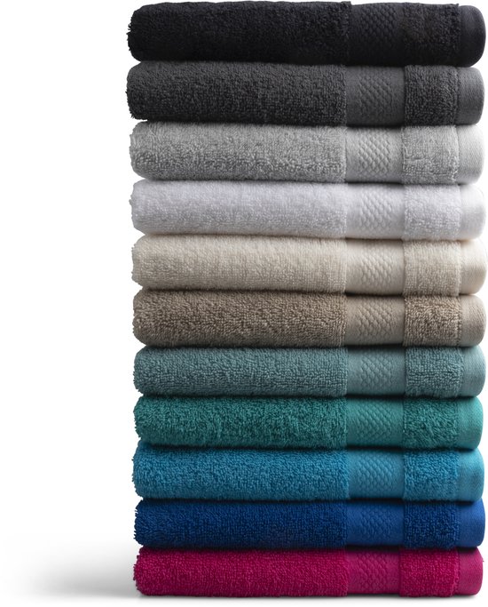 Pile de serviettes de différentes couleurs, du noir et gris au blanc, beige, vert et bleu.