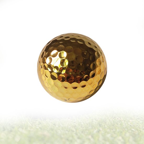 Een glimmende gouden golfbal met kuiltjes, drijvend boven gras.