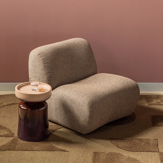 Lichtbruine fauteuil naast bijzettafel met glas water.