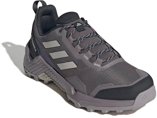 Grijze Adidas Terrex wandelschoen met lichte strepen, zwarte accenten en gespikkelde veters.