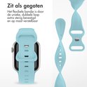 Gedetailleerde afbeelding van een lichtblauw siliconen Apple Watch bandje, dat flexibel en verstelbaar is.