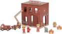 Houten brandweerkazerne met 'FIRE STATION' bord, brandweerwagen, ladder, hydrant, vuurtjes en poppetjes.