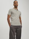 Man draagt een lichtgrijs poloshirt met beige kraag en manchetten met witte bies.