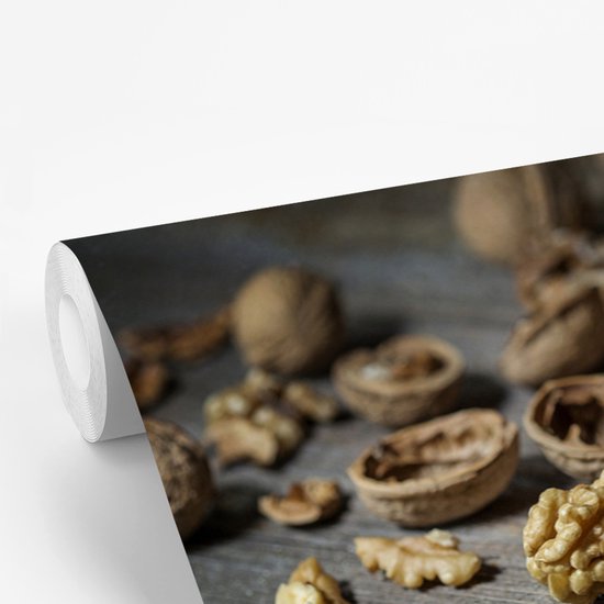 Noix fêlées sur une table en bois foncé fotobehang vinyle largeur 450 cm x hauteur 300 cm - Tirage photo sur papier peint (disponible en 7 tailles)