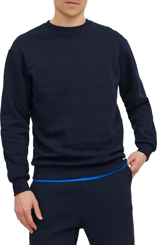 Donkerblauwe sweater met ronde hals, gedragen door een model met een blauwe rand zichtbaar aan de onderkant.