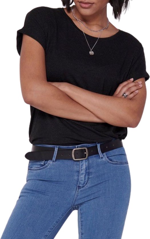 Vrouw draagt een zwarte top met opgerolde mouwen en een spijkerbroek met zwarte riem.