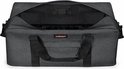 Openstaande donkergrijze Eastpak reistas met zichtbaar interieur.