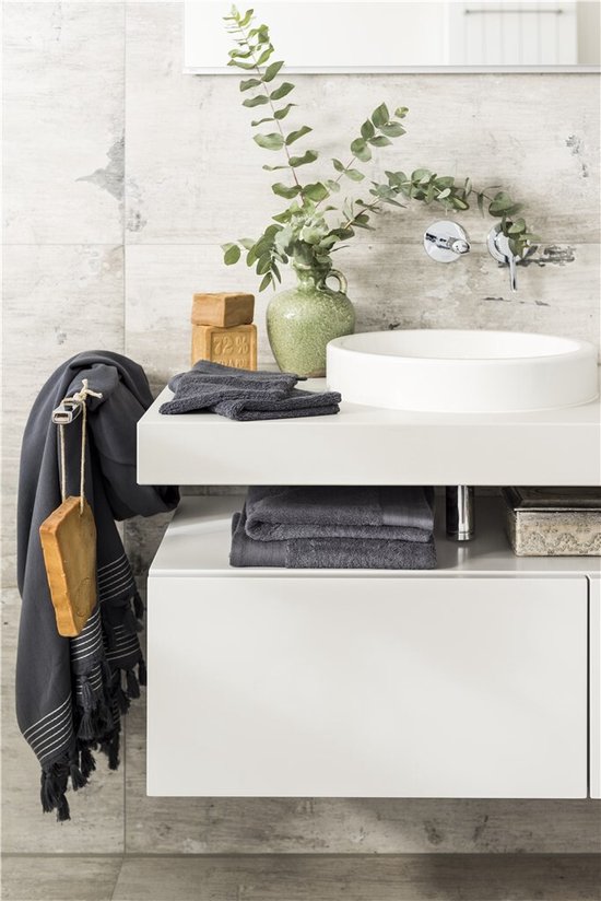 Serviettes gris foncé sur un crochet à côté d'un lavabo.