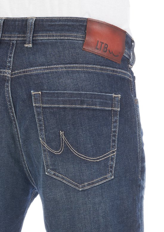 Close-up van de achterkant van een donkerblauwe spijkerbroek met bruin LTB-label.