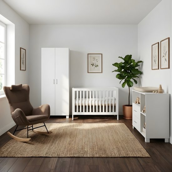 Witte babykamer met commode, ledikant, kast, bruine schommelstoel en plant.