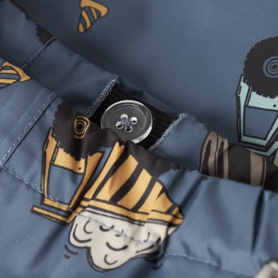 Detail van blauw regenpak met opdruk van bouwmachines, met zichtbare naad en knoop.