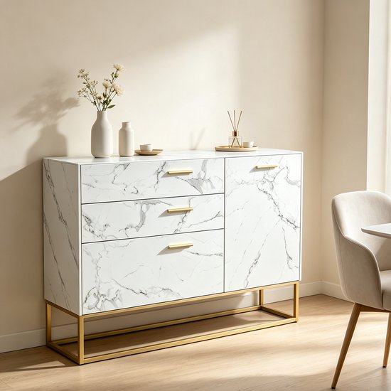 Wit marmerlook dressoir met gouden handvatten en frame, gestyled in een woonkamer met een stoel.