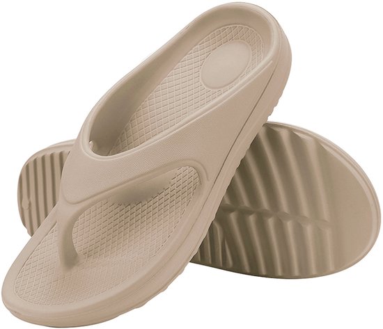 Twee beige slippers, met een textuur op de zool.