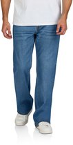 Model draagt een blauwe bootcut spijkerbroek van DENIMFY met witte sneakers.