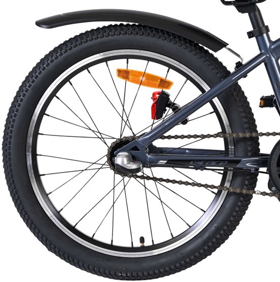Achterwiel van een grijze kinderfiets met zwarte band, zilveren velg en versnellingsapparaat.