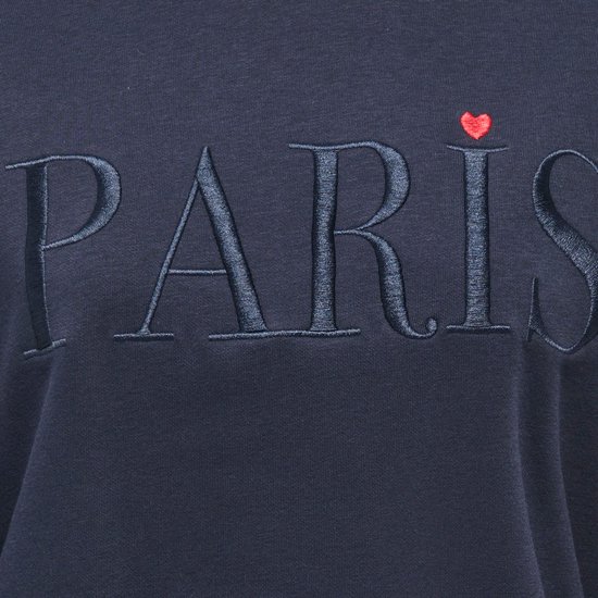 Detailopname van de 'PARIS' opdruk in reliëf met rood hartje op een donkerblauwe sweater.