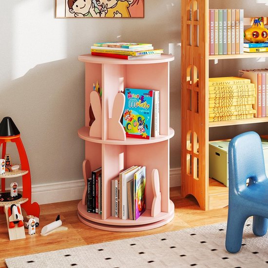 Roze draaibare boekenkast voor kinderen met twee niveaus, met konijnvormige boekensteunen, boeken en potloden erop.