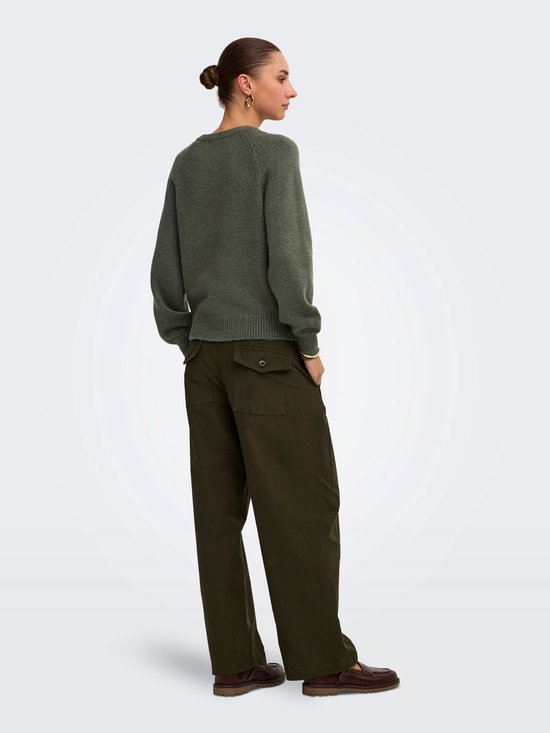 Vrouw in donkergroene trui met broek met cargo zakken, rug en zijkant zichtbaar.
